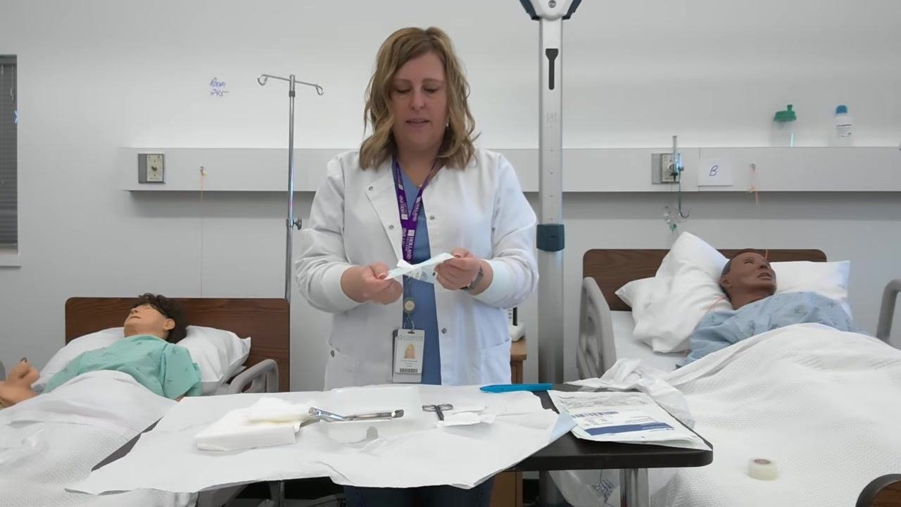 A healthcare professional holds gauze packaging while confirming placement within the sterile field. The tray is organized with all supplies inside the drape.