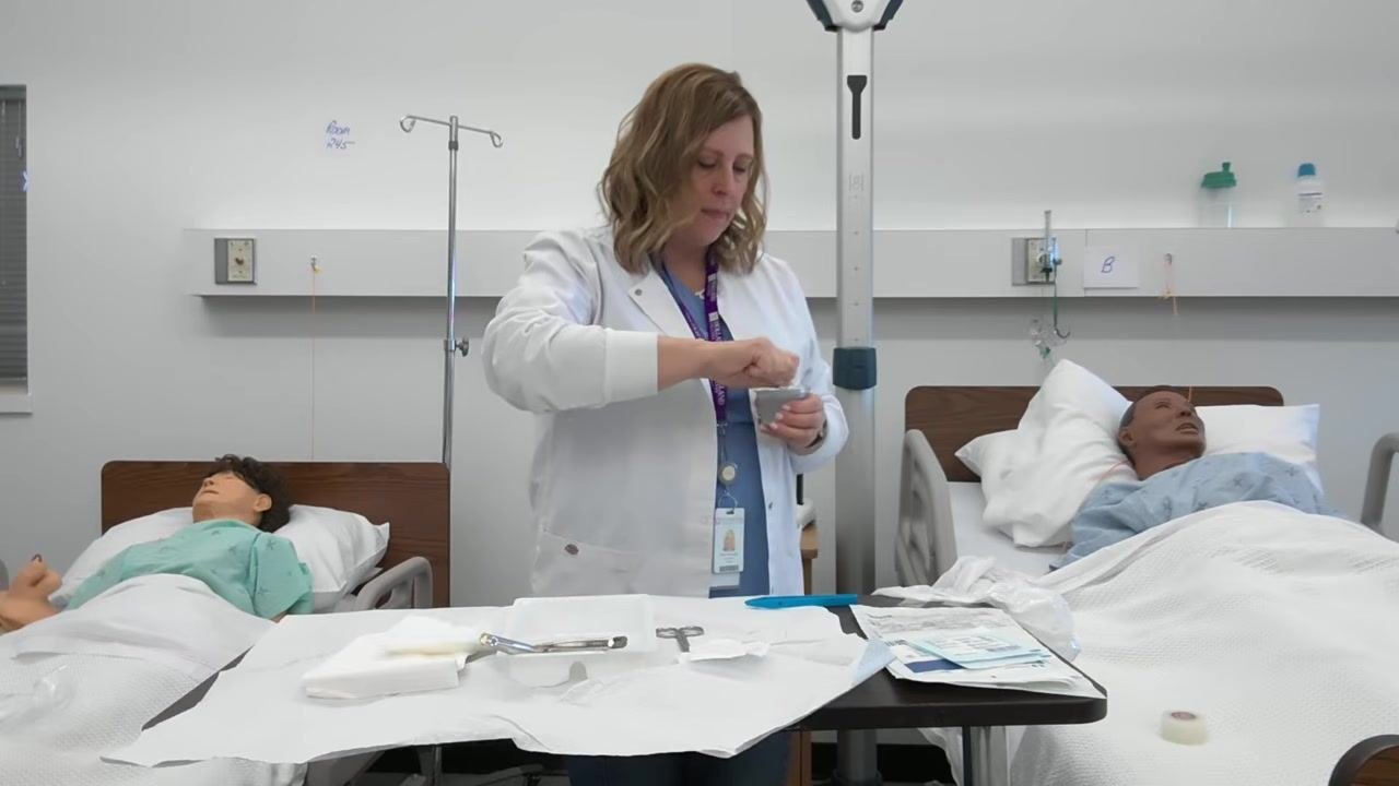 A healthcare professional opens the saline solution container, preparing to "lip" it by pouring a small amount out.