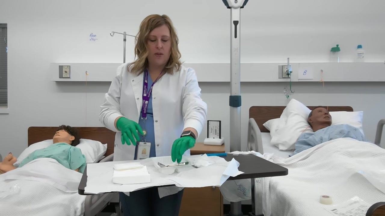 A healthcare professional reaches to discard a used item, demonstrating proper disposal technique.
