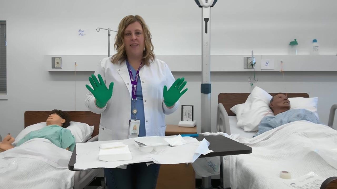 A healthcare professional faces forward with both gloved hands raised, summarizing the procedure. The sterile tray is organized and ready for use.