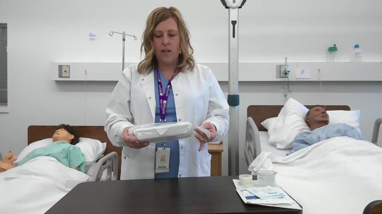 A healthcare professional closely inspects the dressing tray packaging for any breaks or tears.