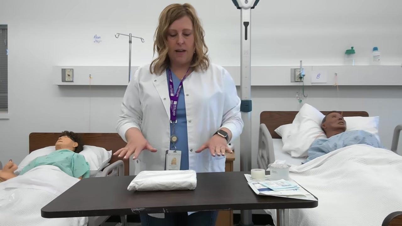 A healthcare professional gestures towards the tray, demonstrating the correct way to open the packaging flap away from the body.