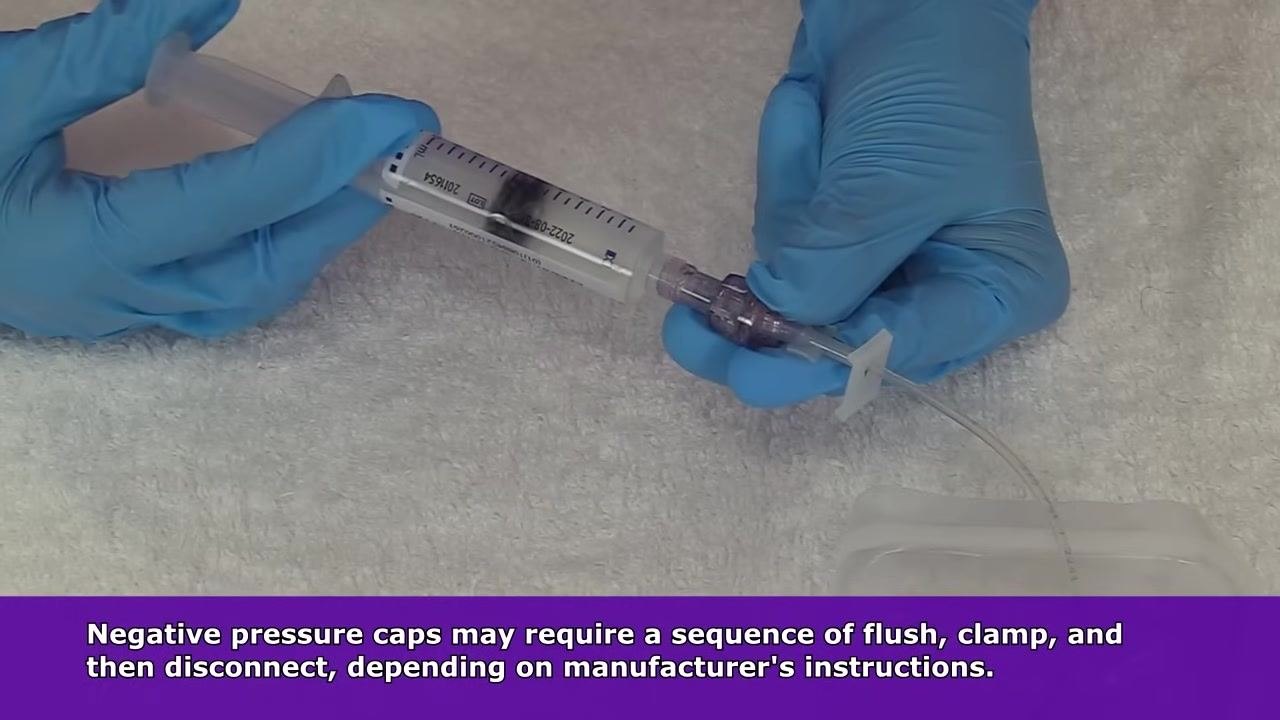 Applying a sterile dressing over the IV site on the patient's hand, with the extension set and Curos cap visible and a blue tourniquet in the background