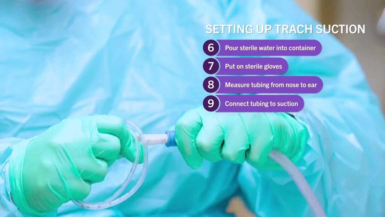 Clinician in PPE demonstrating wrapping suction catheter tubing around hand, maintaining control and sterility