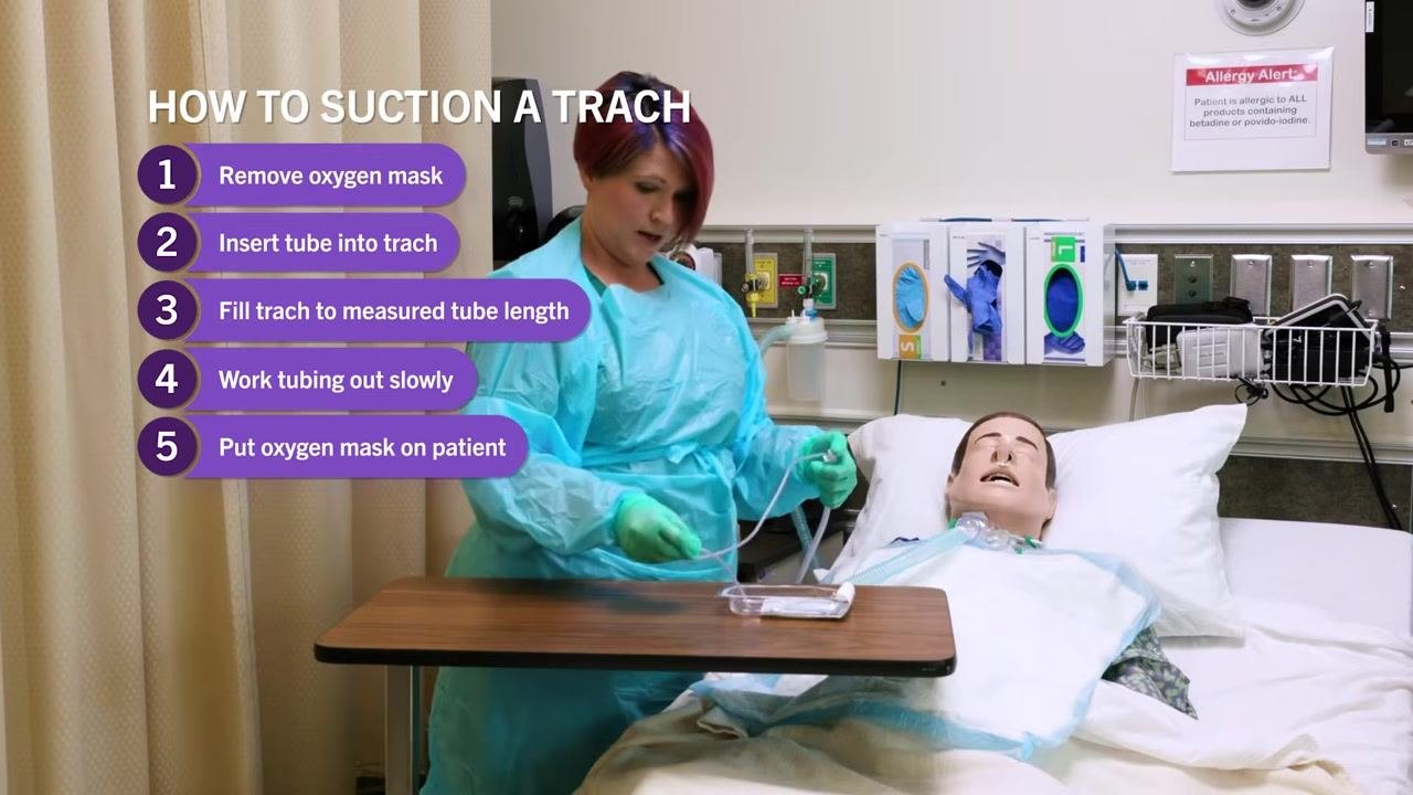 Clinician in PPE holding suction catheter at measured depth, on-screen checklist visible