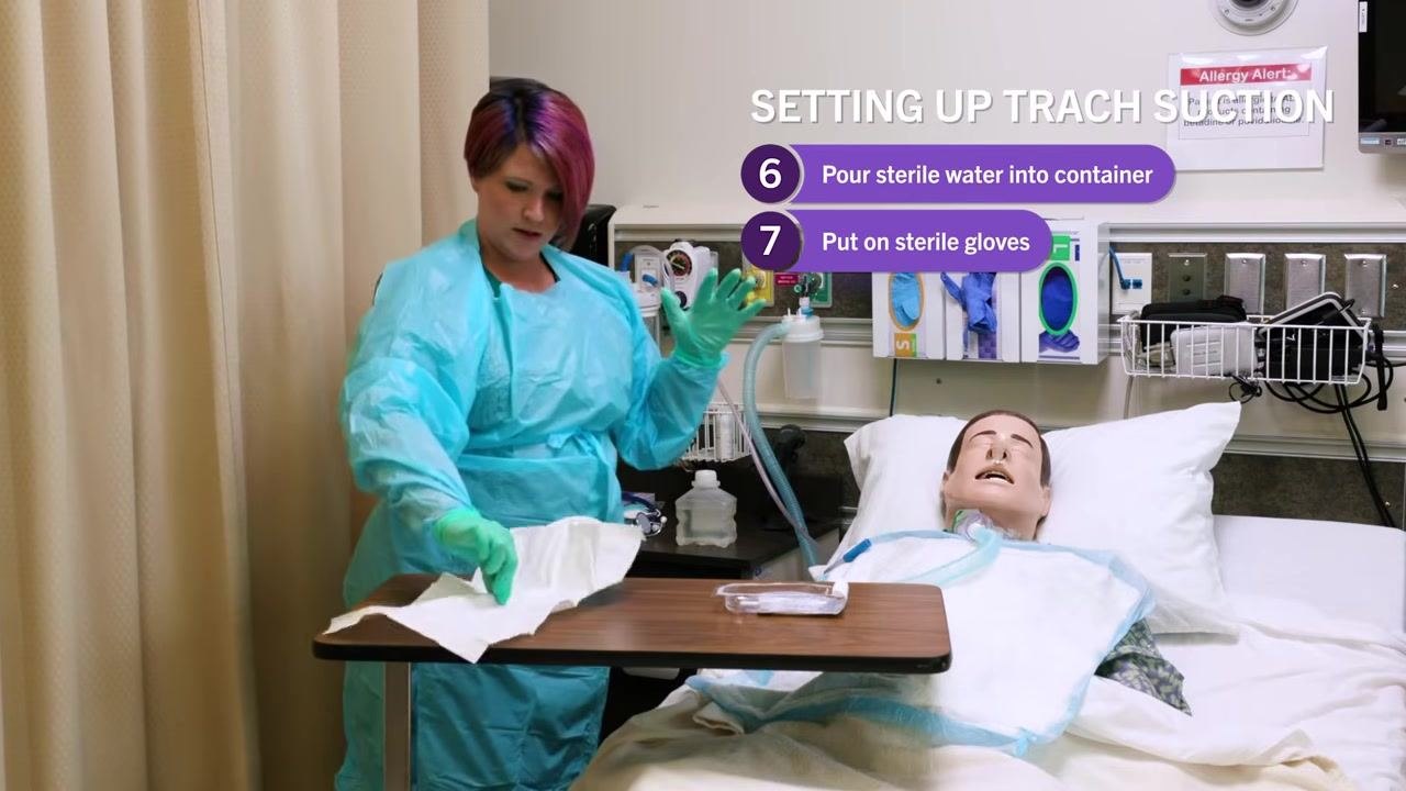 Nurse in blue gown moving packaging away from the sterile field on the bedside table, maintaining a clear workspace. On-screen checklist: "6. Pour sterile water into container, 7. Put on sterile gloves"