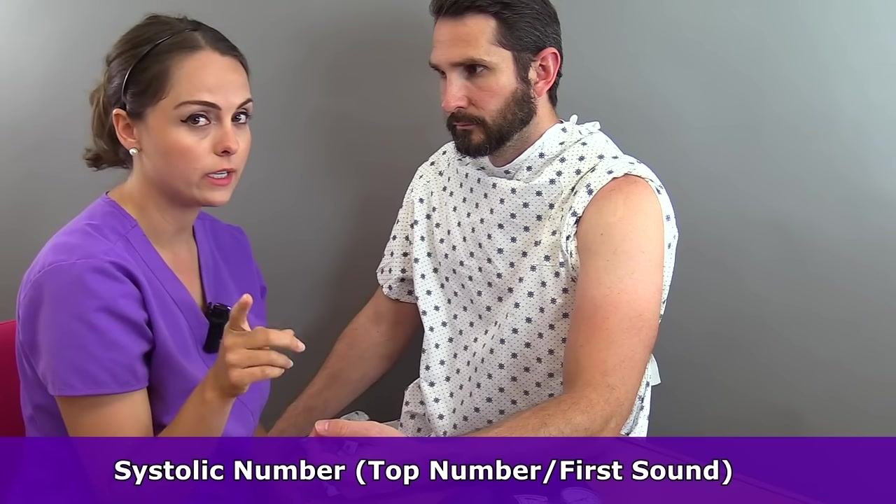 Nurse explaining the importance of correct cuff size, gesturing with both hands, with the cuff visible on the table