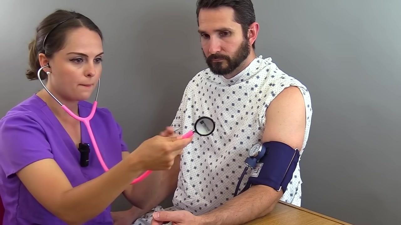 Nurse holding a stethoscope, preparing to use the bell side, with the cuff on the patient's arm, both focused on the procedure
