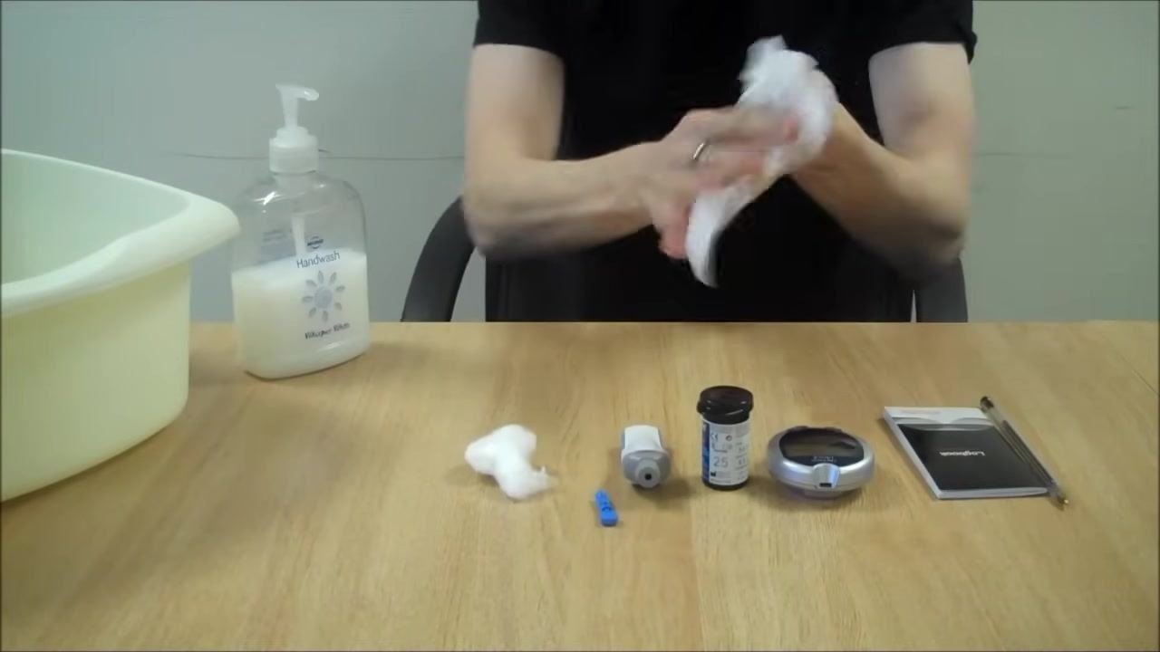 Person rubbing hands with a paper towel to ensure dryness, with equipment visible on the table