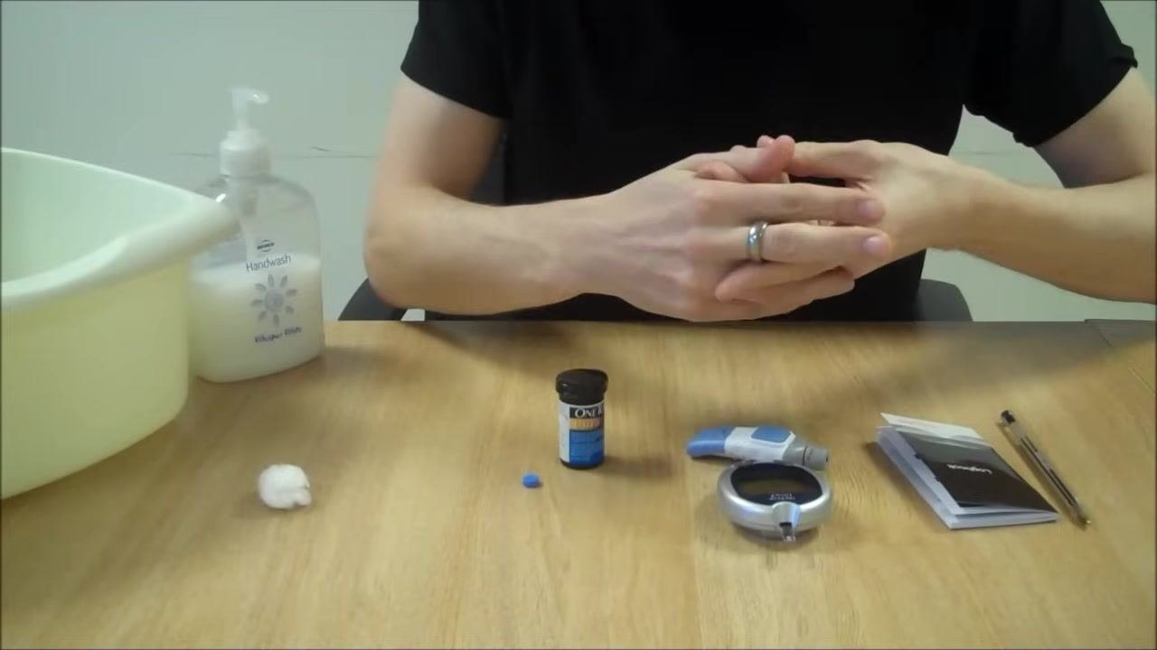 Person gently squeezing their finger after pricking, preparing to collect a blood sample