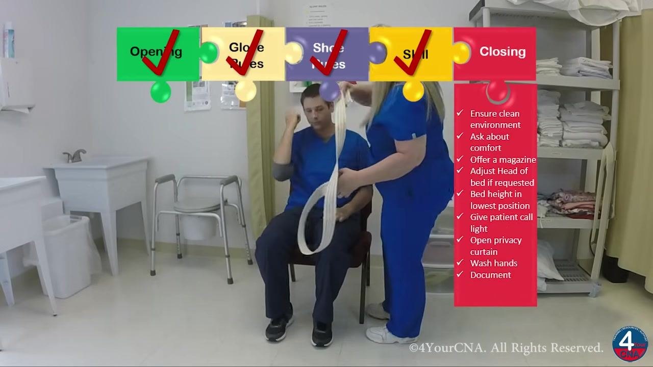 Caregiver and resident standing in front of the chair, with the caregiver demonstrating hand placement for a safe sit-down