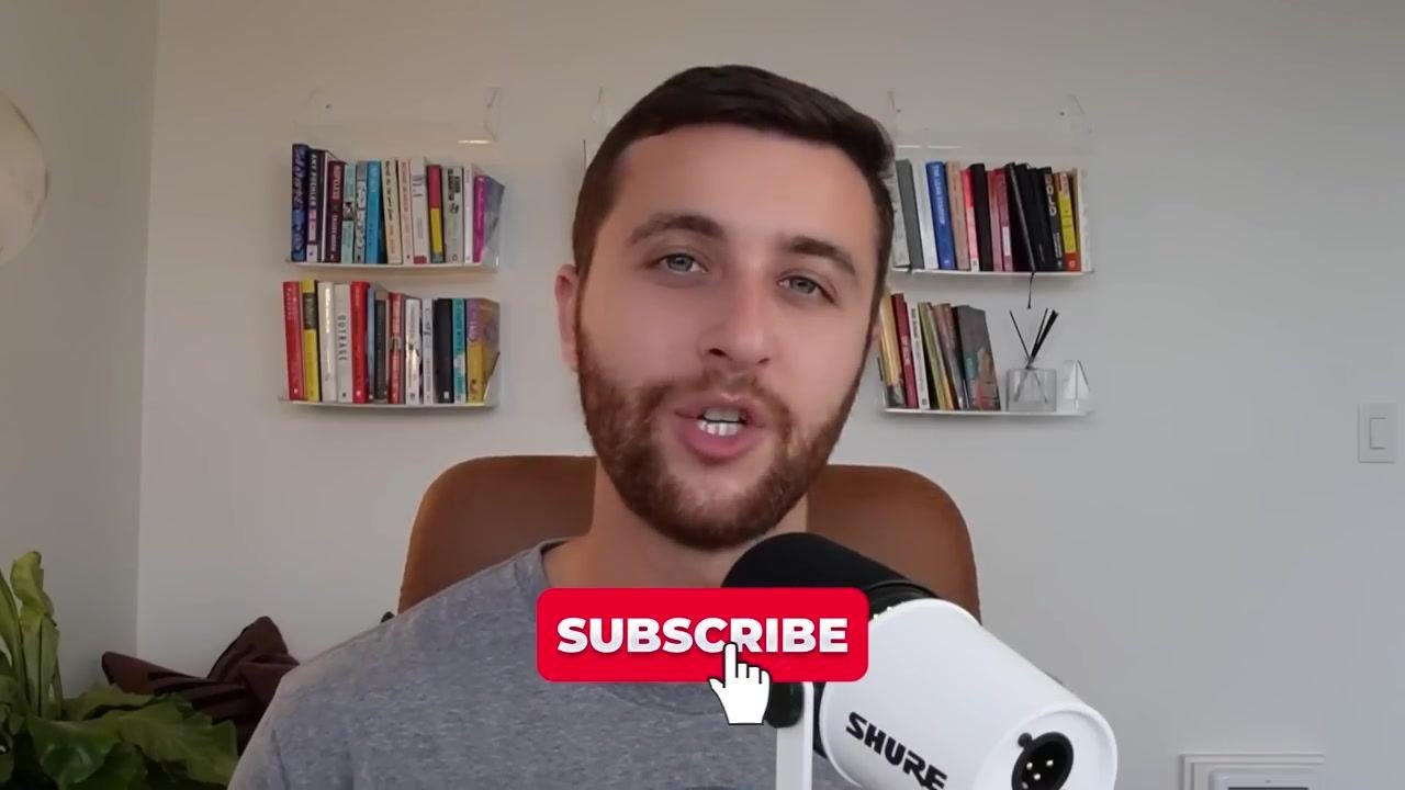 A person speaking into a microphone in a home office with bookshelves in the background. A large red "SUBSCRIBE" button with a hand cursor is overlaid on the image.