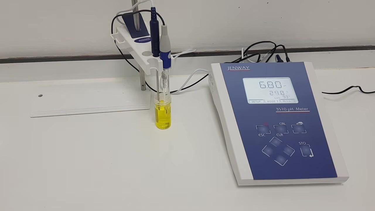 Both probes submerged in the pH 7 buffer solution; the pH meter display shows calibration in progress