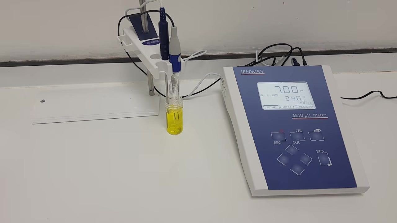 pH meter display shows 7.00 pH with probes still in the yellow pH 7 buffer solution; Jenway 3510 pH Meter and probe holder visible