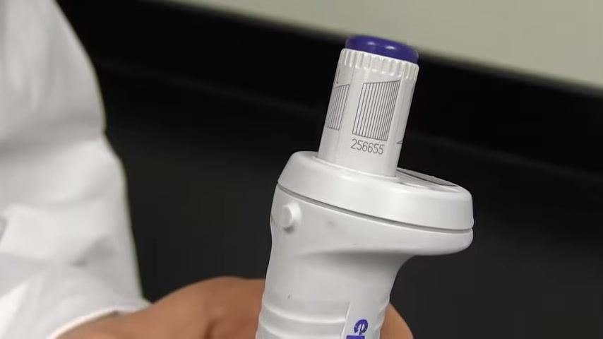 Close-up of the pipette showing serial number "256655" on the adjustment dial.