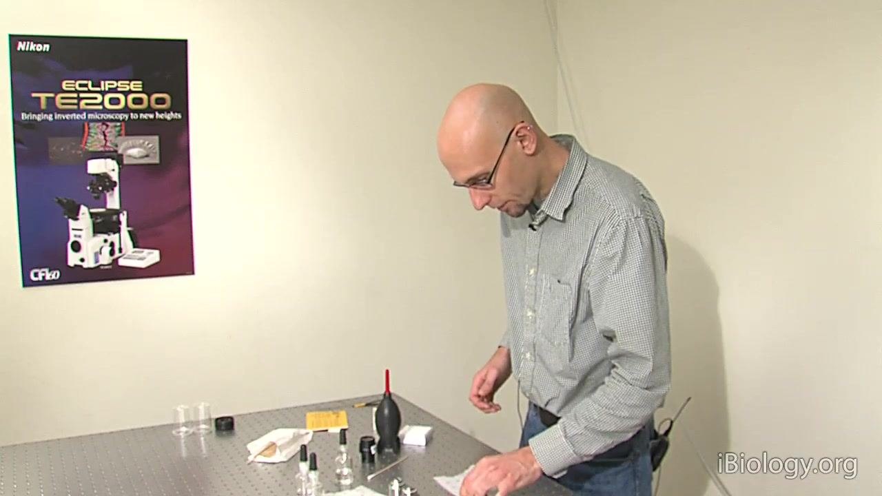 A person prepares to use an air blower to clean a filter, with cleaning supplies visible.