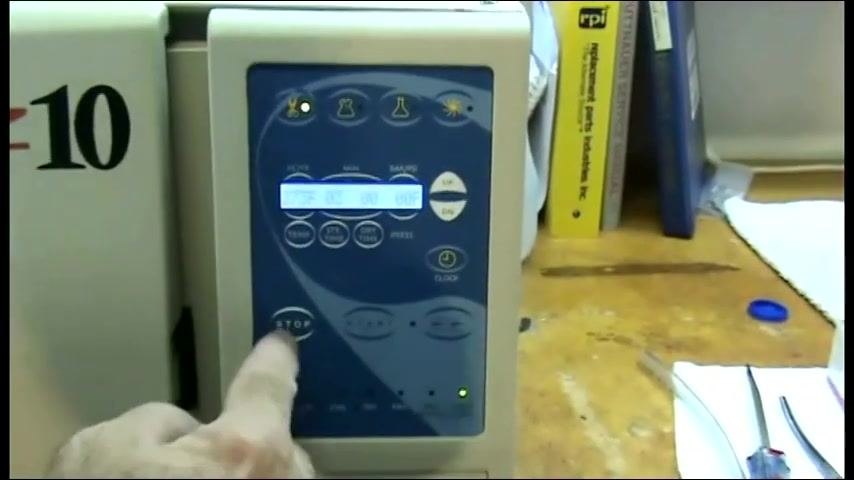 The operator's finger on the control panel selecting the appropriate cycle, with the display and buttons visible.