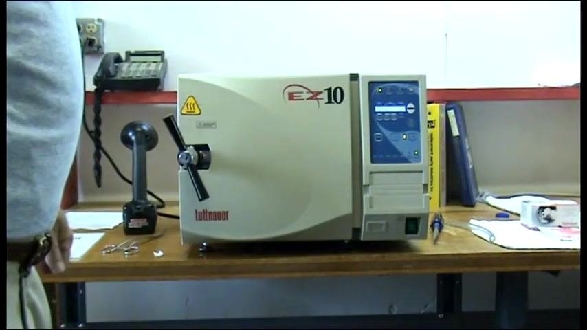 The autoclave display showing the cycle is complete, with the unit closed and idle on the workbench.