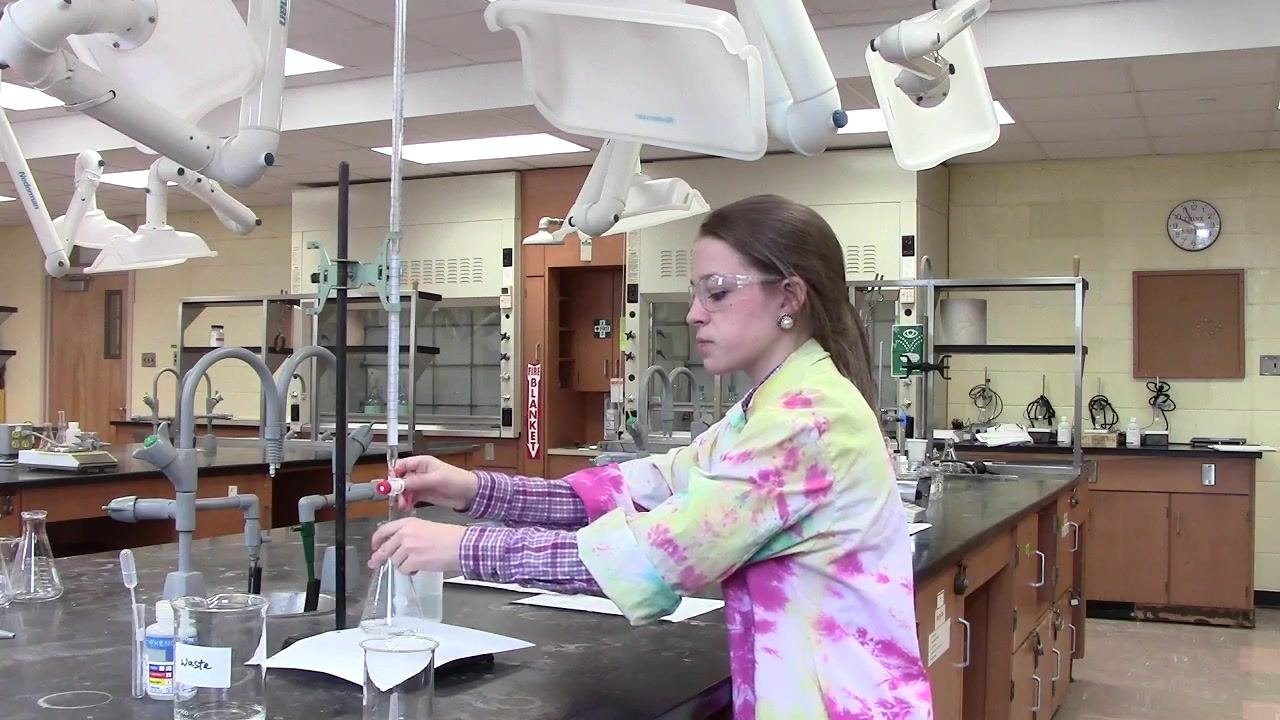 Person controlling the burette stopcock and swirling the flask to ensure proper mixing during titration.