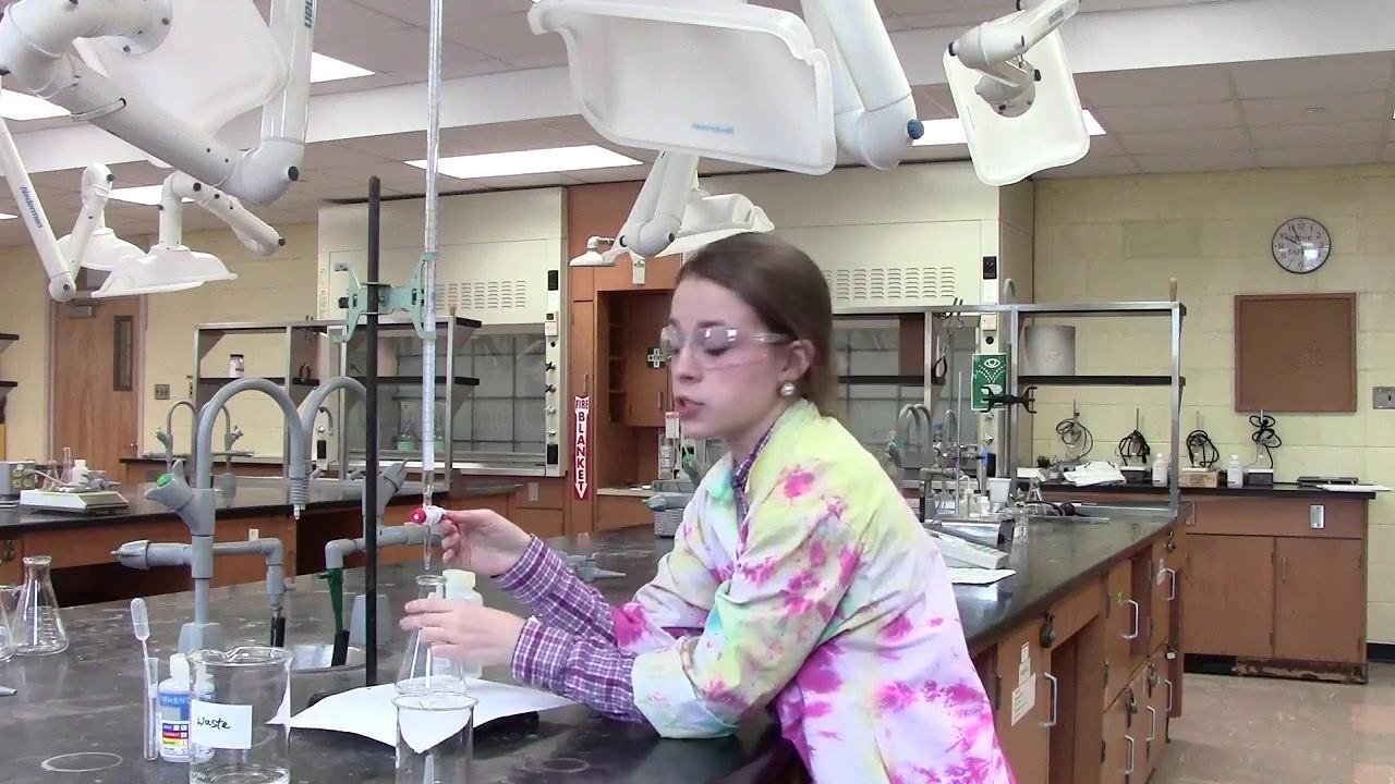 Person using the dominant hand to swirl the flask and the weak hand to control the burette stopcock.