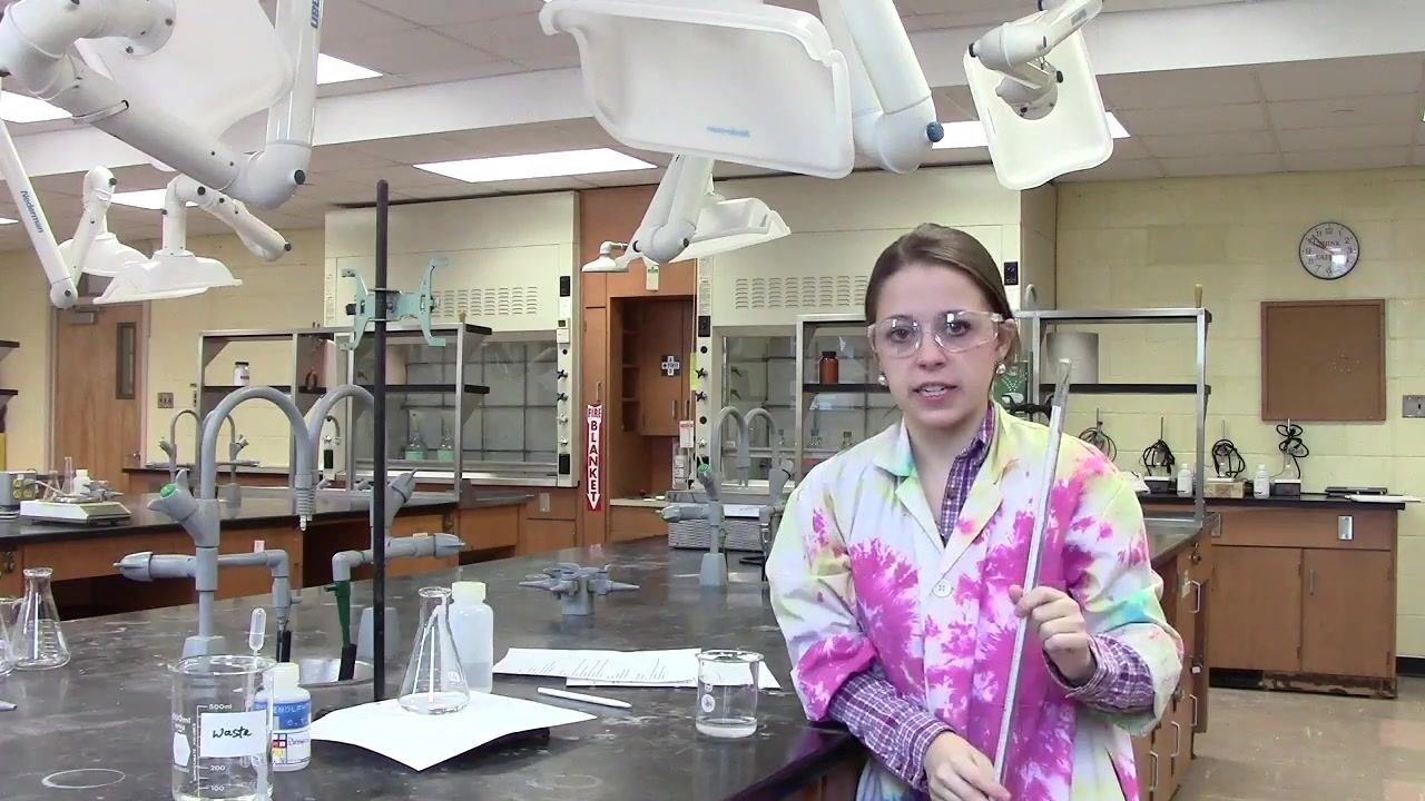 Person holding the burette vertically in preparation for rinsing with water.