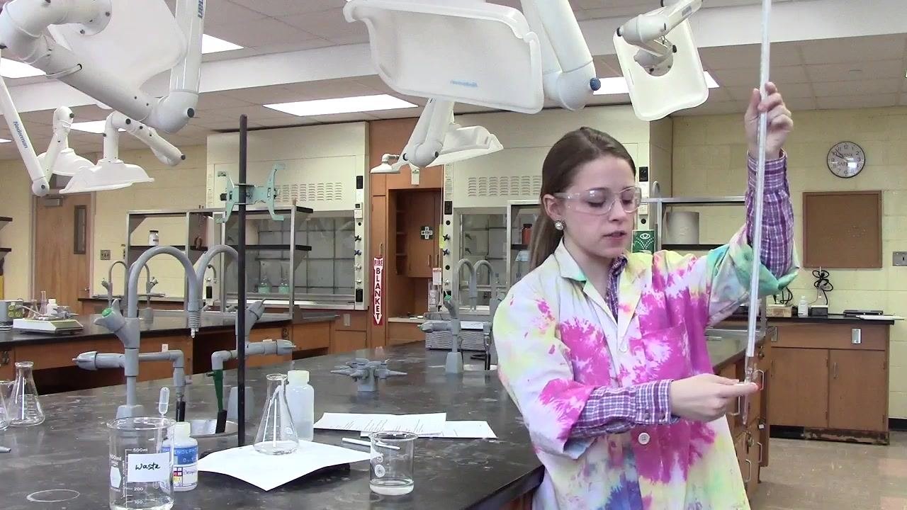 Person pouring solution into the burette through a funnel, with the stopcock closed.