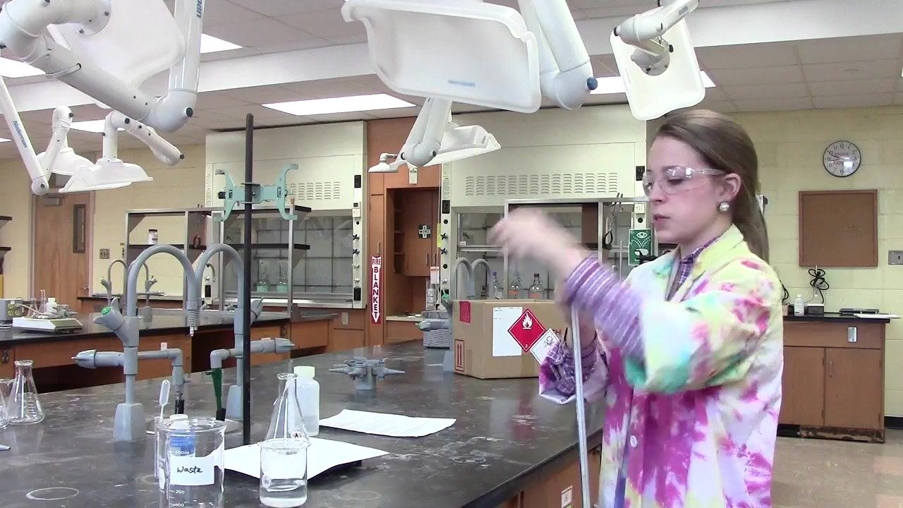 Person rotating the burette horizontally to rinse the sides and tip.