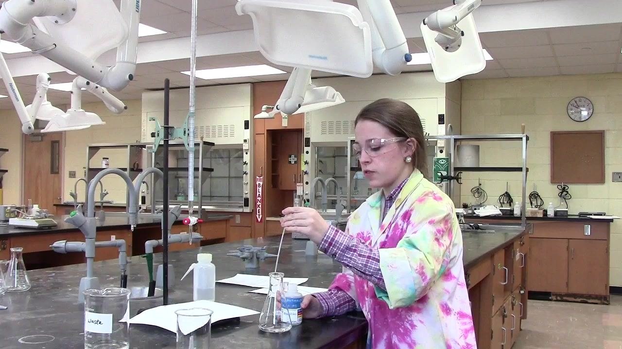 Person adding phenolphthalein indicator to the Erlenmeyer flask containing the unknown solution.