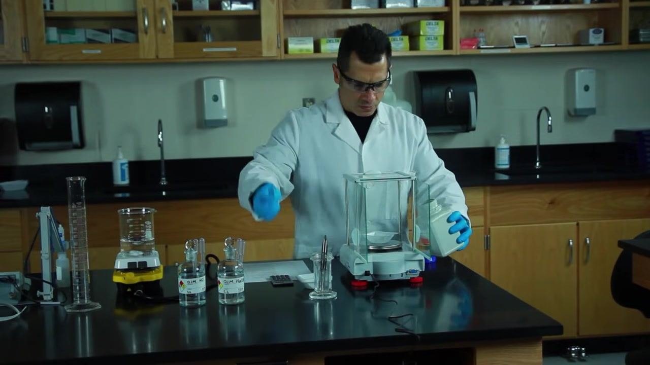 Beaker on a stir plate containing a clear solution with a visible stir bar at the bottom