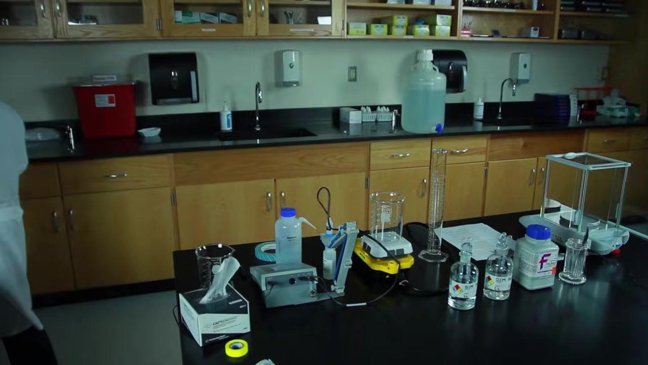 Inserting the pH probe into the beaker with the finished clear buffer solution