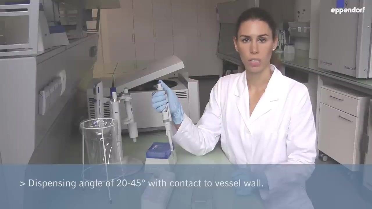 Pipette tip immersed in a microcentrifuge tube containing green liquid, lid open; on-screen text reads "Pre-wet the tip 2-3 times. Dispense all liquid before aspirating sample liquid."