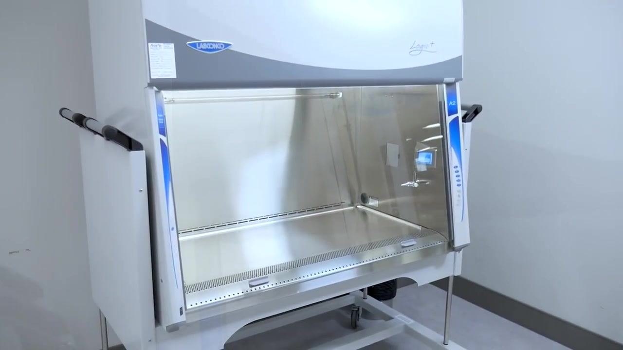A worker rolls up her sleeves and prepares her workspace beside the cabinet before starting work.