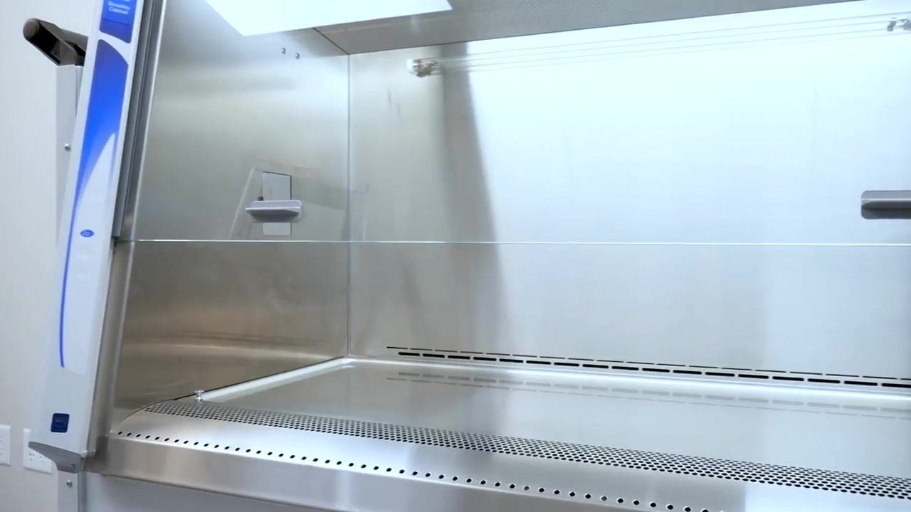 The illuminated, empty cabinet displays a digital screen and the airflow visualizer device during the equilibration period.
