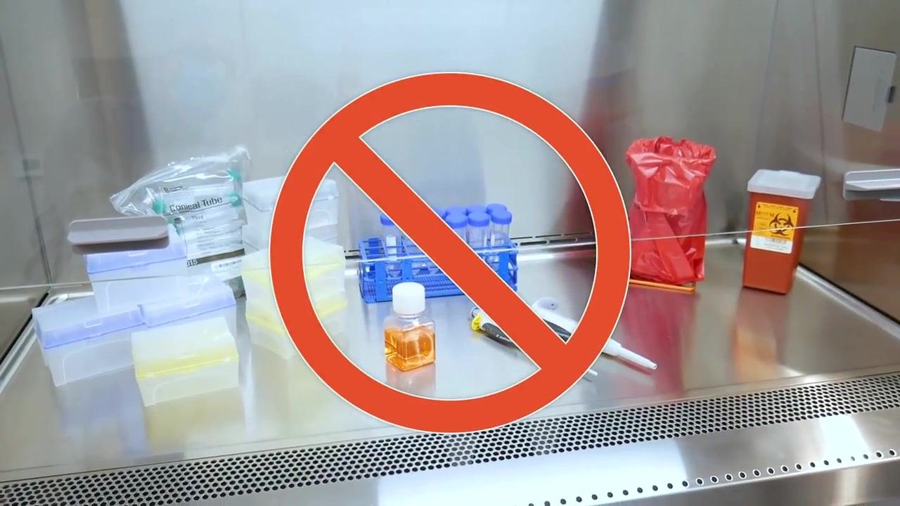 The work surface is cluttered with multiple items blocking the airflow grills, marked with a red "no" symbol to show incorrect arrangement.