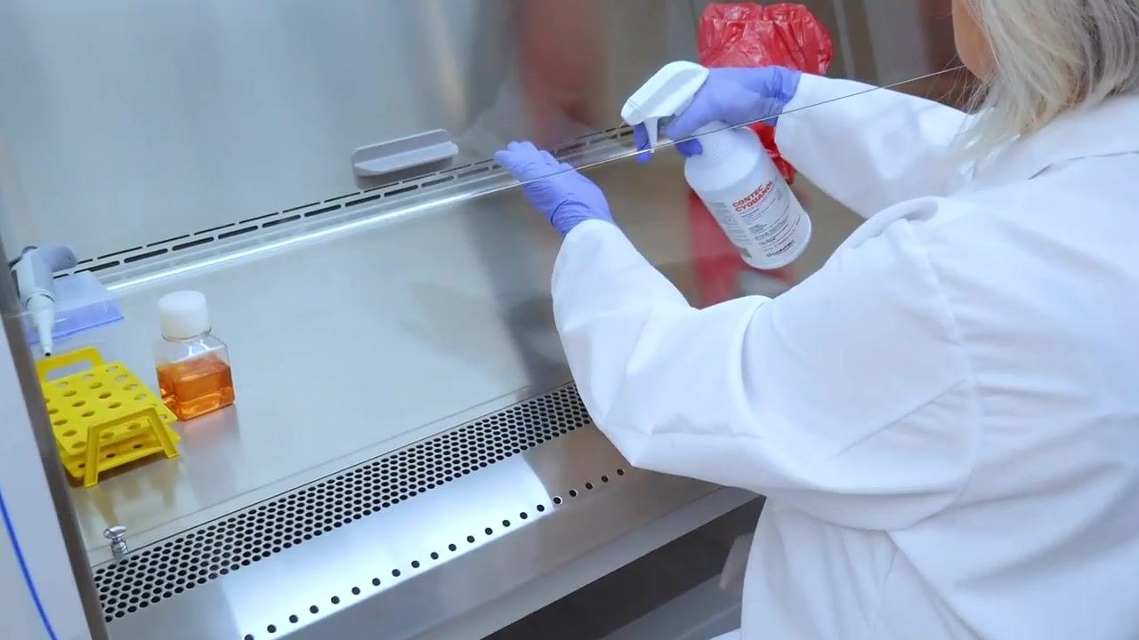 A biohazard waste bag is positioned at the rear of the cabinet, away from the active work area.