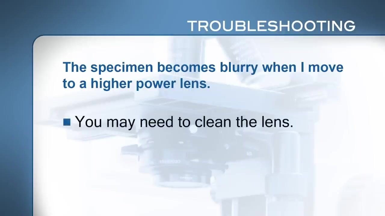 Troubleshooting note stating that the specimen becomes blurry at higher power and the lens may need cleaning, shown against a microscope background