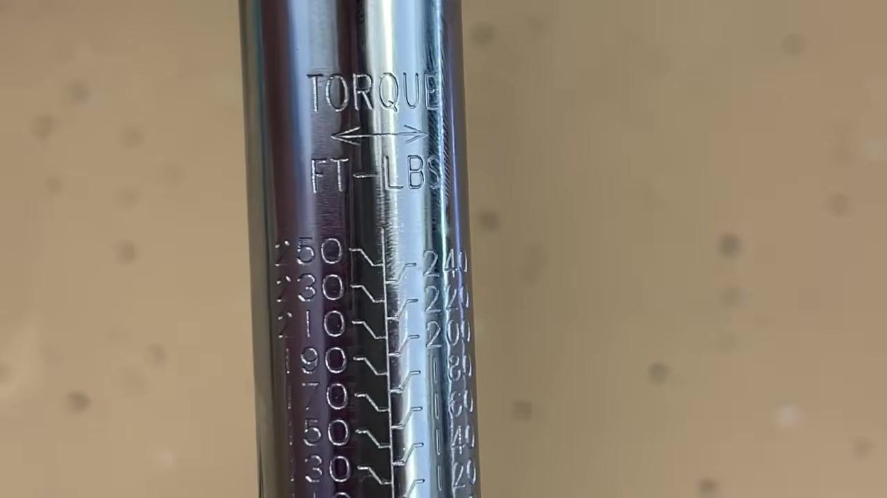 Close-up of the torque wrench shaft showing the FT-LBS scale, with values from 50 to 250 foot-pounds.