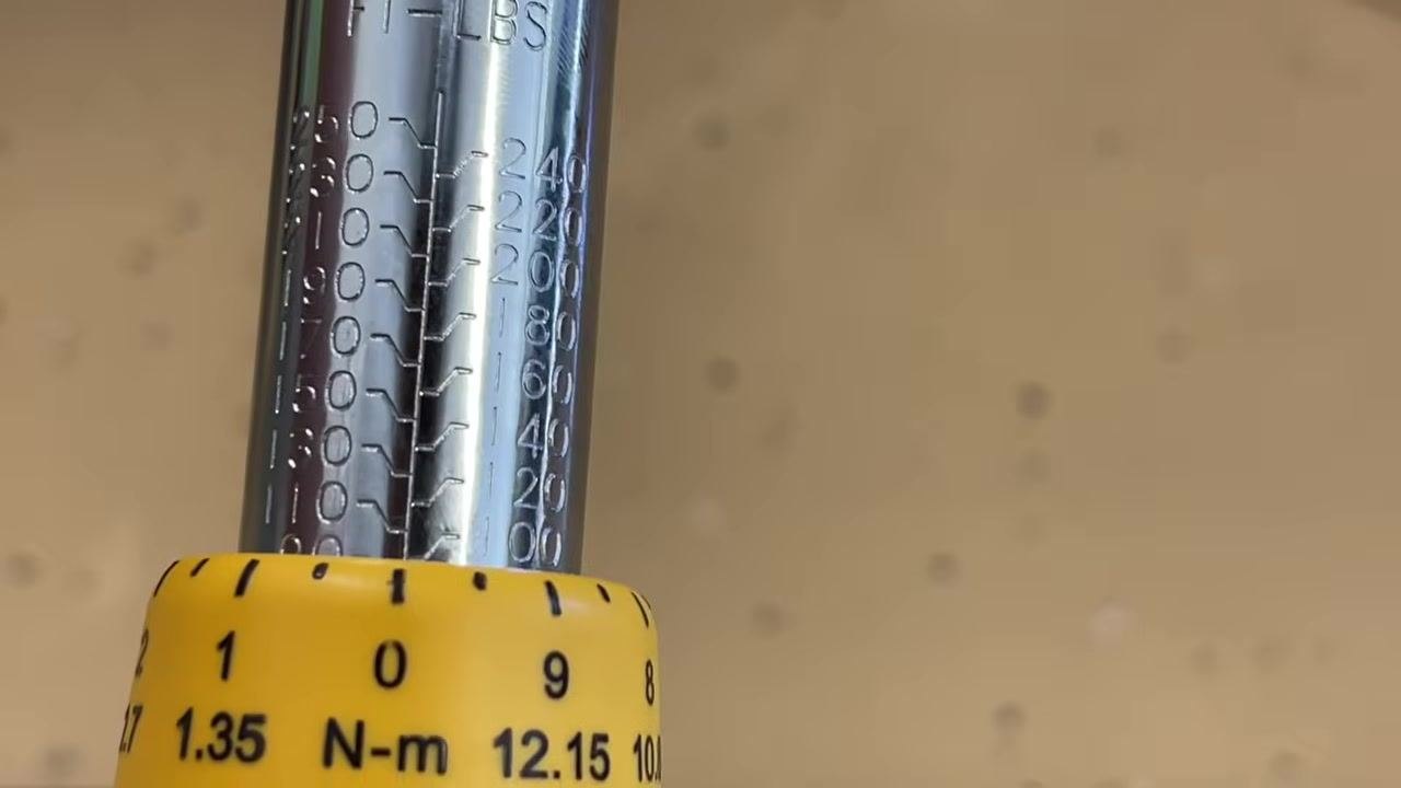 Torque wrench set exactly to 100 ft-lb, with the zero mark on the dial aligned with the drop-down line from the 100 mark.