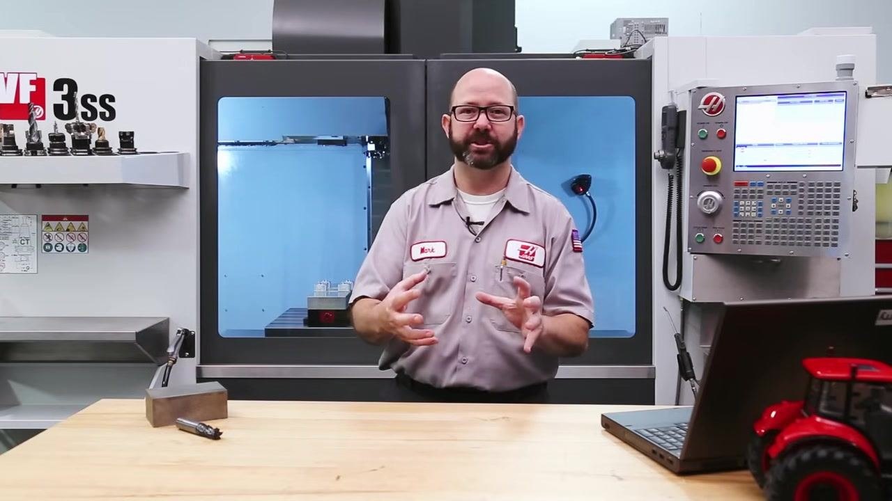 Instructor gesturing to illustrate the importance of setup rigidity for cutting speed selection.