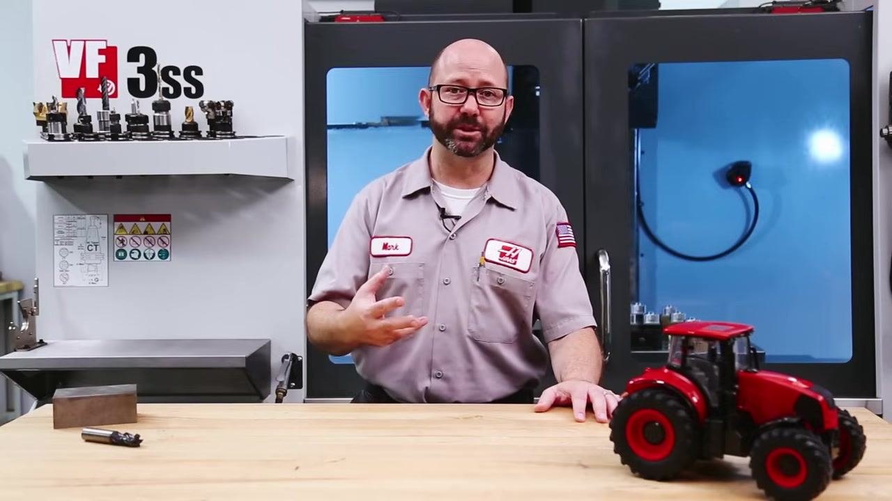 Instructor gesturing while explaining the importance of knowing the tool and its coating in a machine shop setting.