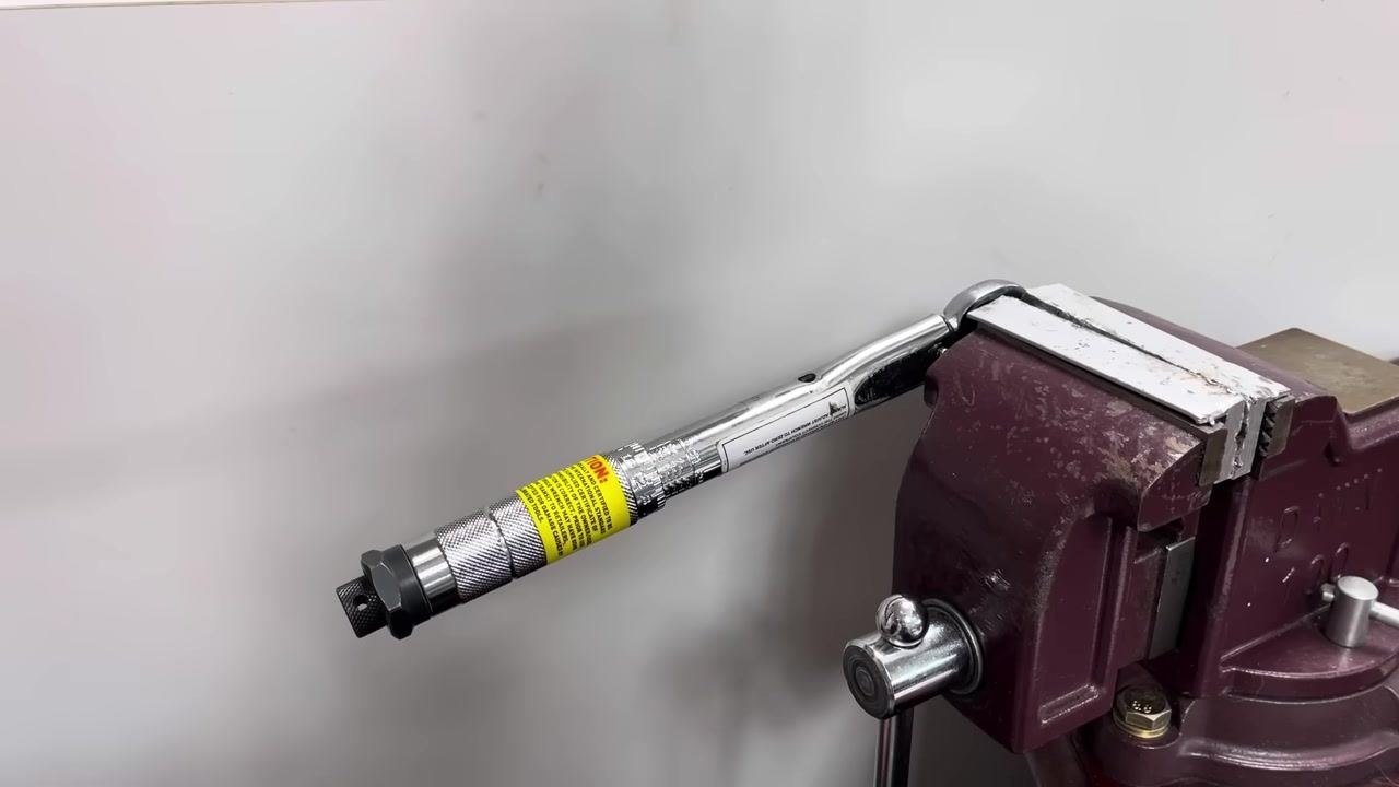 The torque wrench is clamped in the vice, ready for testing at a different position.