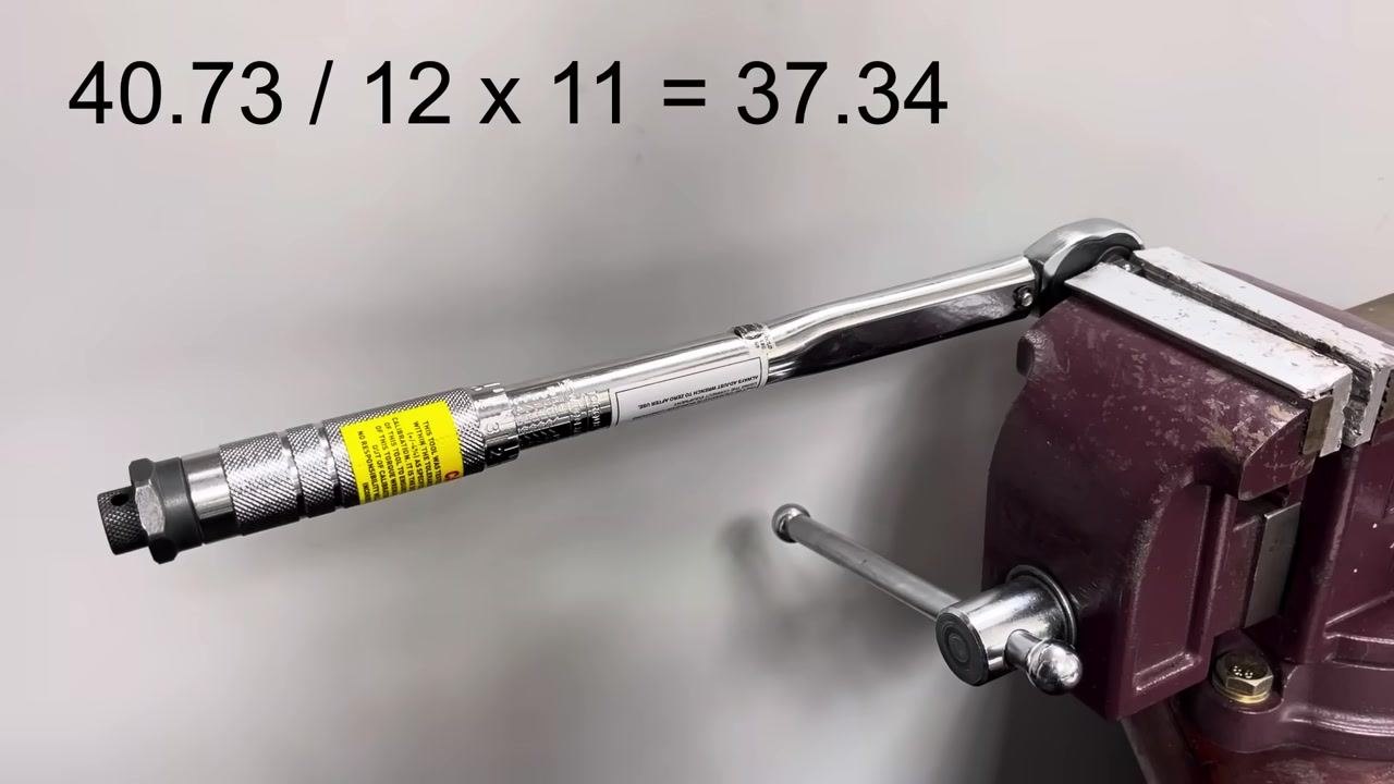 The torque wrench remains in the vise, with the completed calculation "40.73 / 12 x 11 = 37.34" displayed.