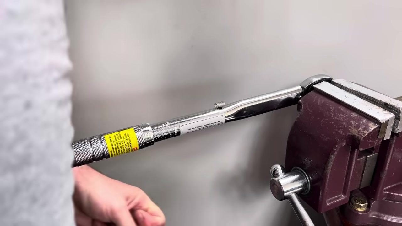 The torque wrench is set up in the vice for testing in a different handle position.