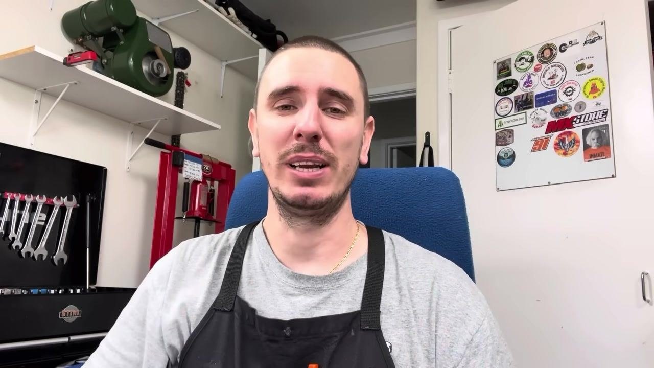 A person sits in a workshop, explaining troubleshooting steps and final advice for torque wrench calibration. Various tools and stickers are visible in the background.