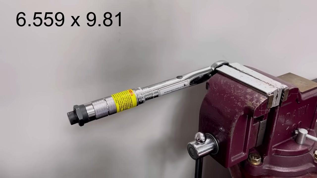 A torque wrench is clamped in a vice with a rope attached to the handle. The display shows "7.5kg," though the actual measured weight is 6.559 kg.