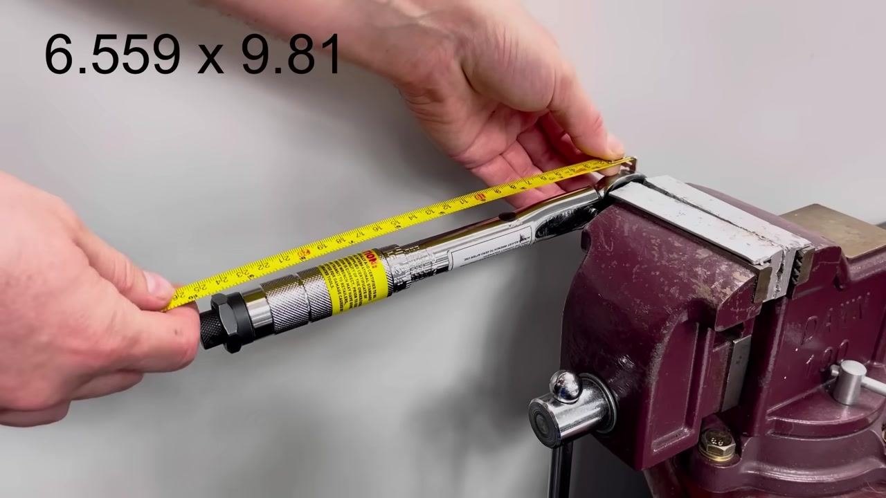 The torque wrench remains clamped in the vice. The calculation "6.559 x 9.81" is shown on screen.