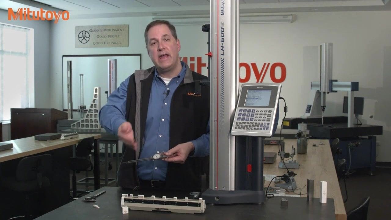 A 0.150-inch gauge block held in front of a calibration fixture labeled "INSIDE," with a 1-inch Mitutoyo gauge block visible on the table