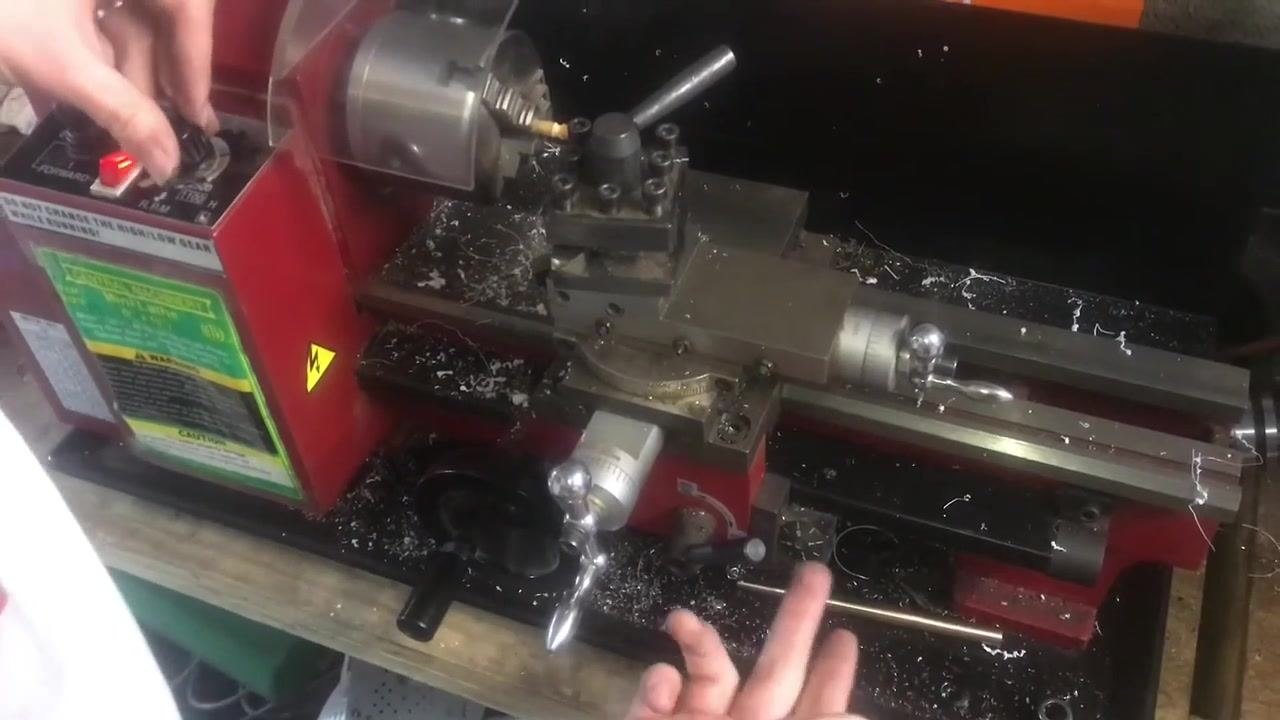 An operator's hand near the carriage handwheel, indicating the process of aligning the tool to pick up the thread.