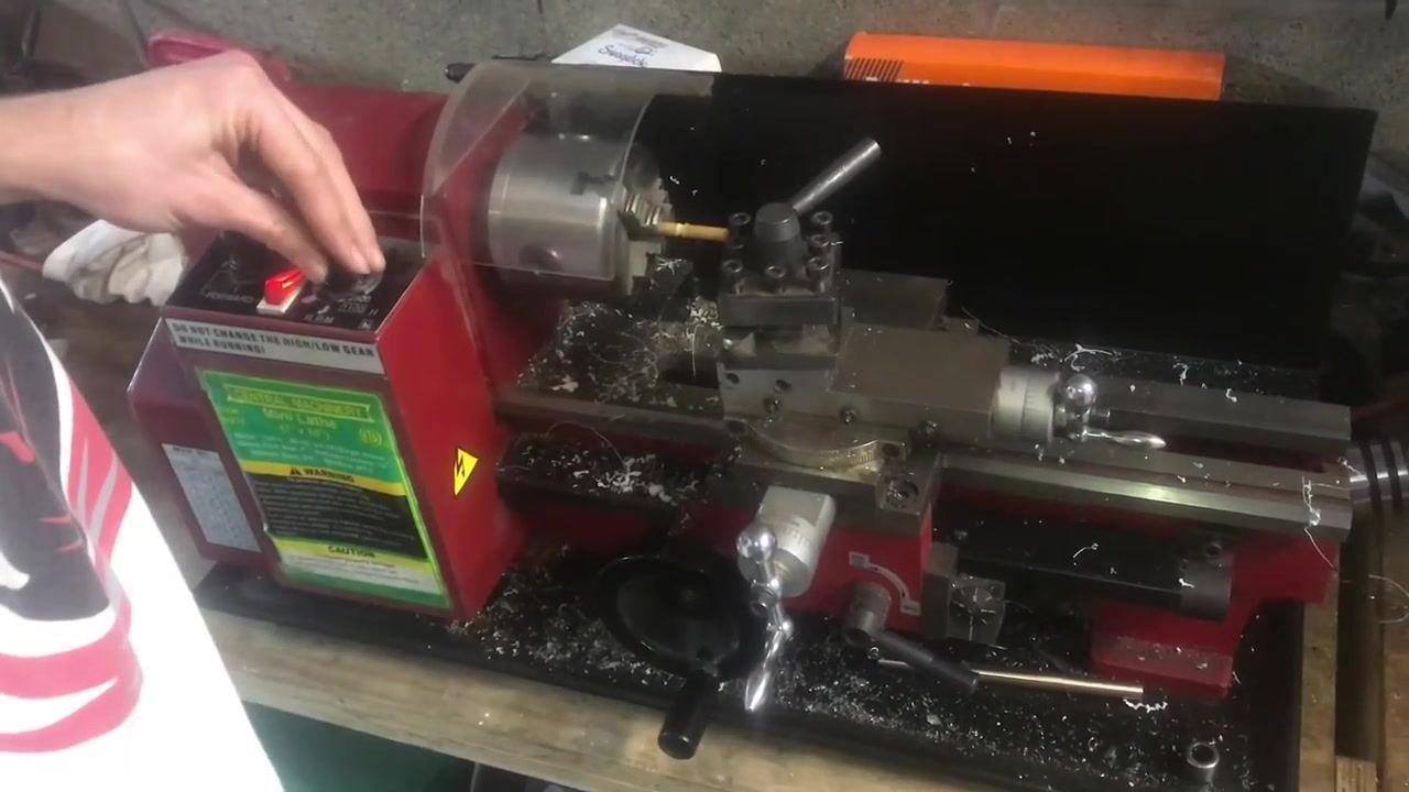 A close-up of the workpiece in the chuck with a thread gauge being used to check the thread pitch.