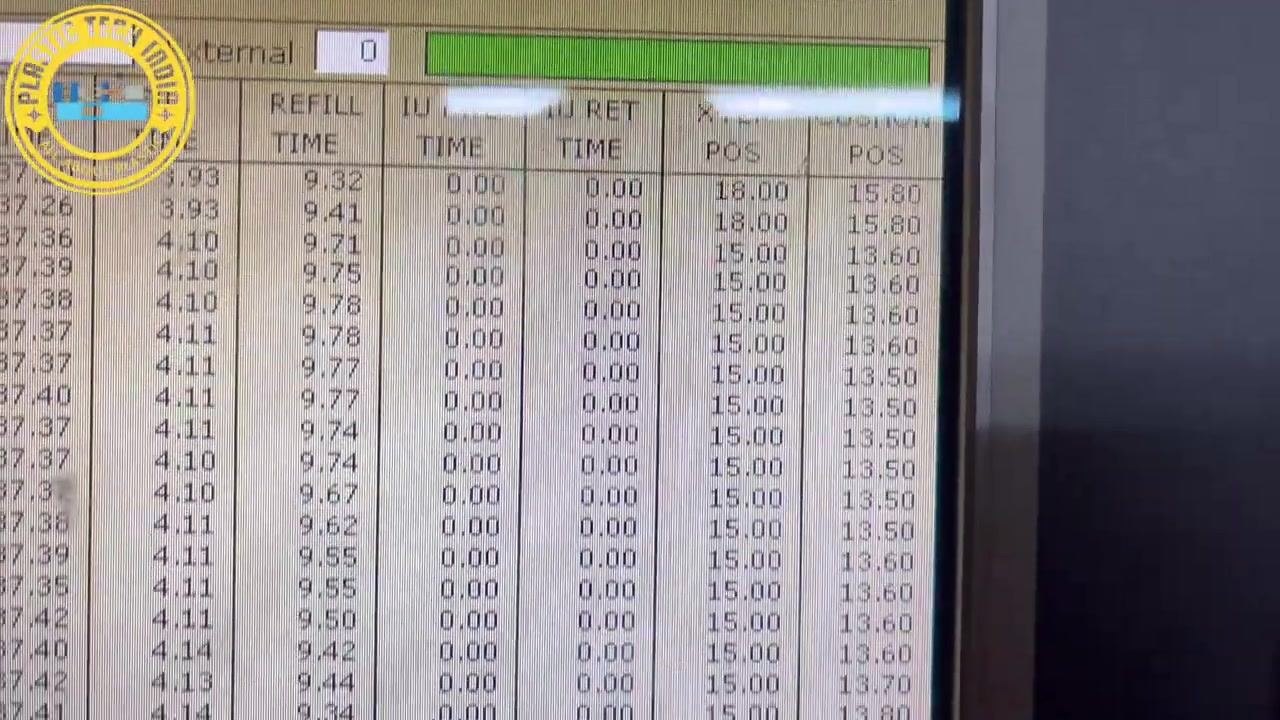 Operator pointing to the 'CUSHION POS' column on the machine interface, highlighting a value of 15.80 mm on a table of process parameters.